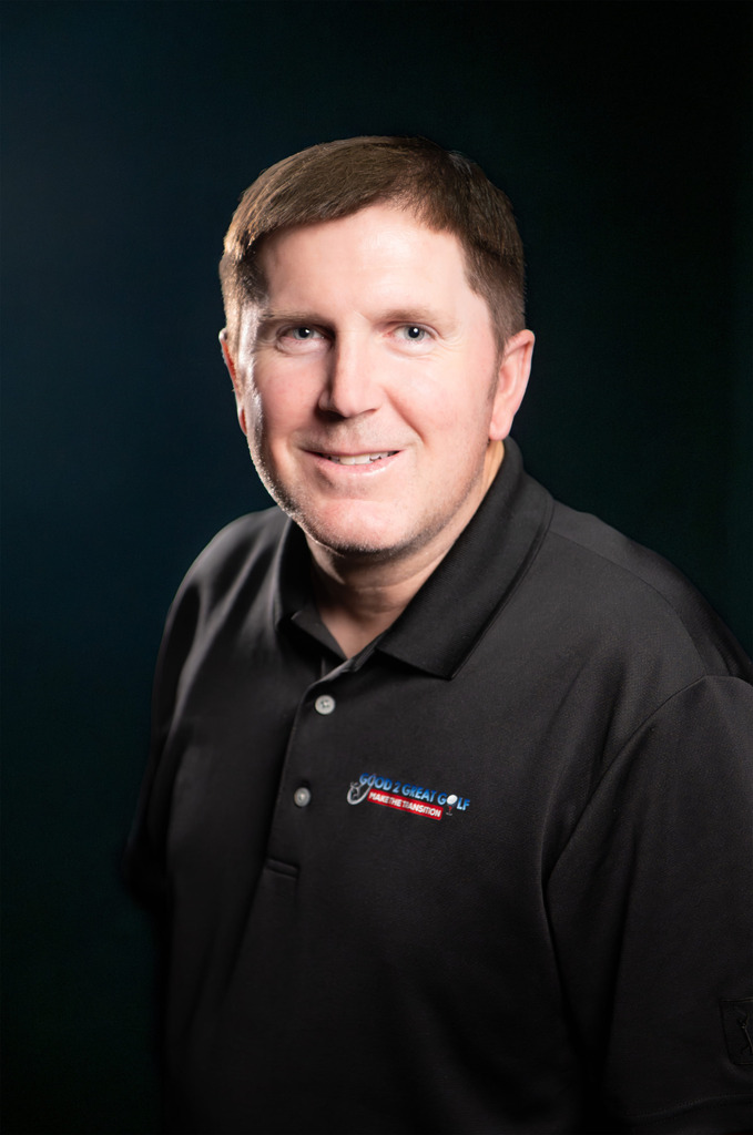Professional headshot of man in black polo