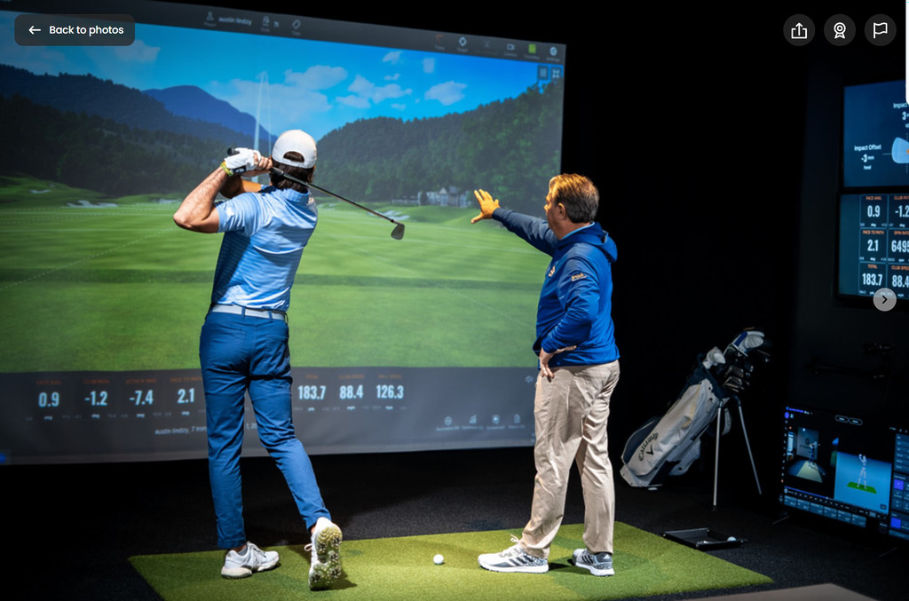 Golfer practicing swing in indoor simulator studio