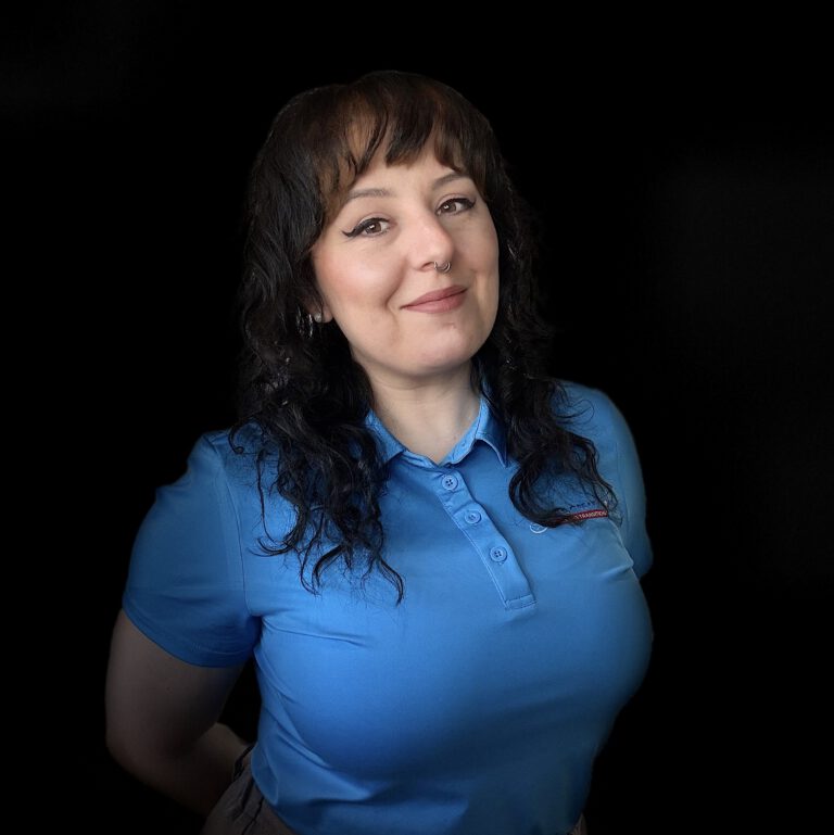 Woman in blue polo against black background