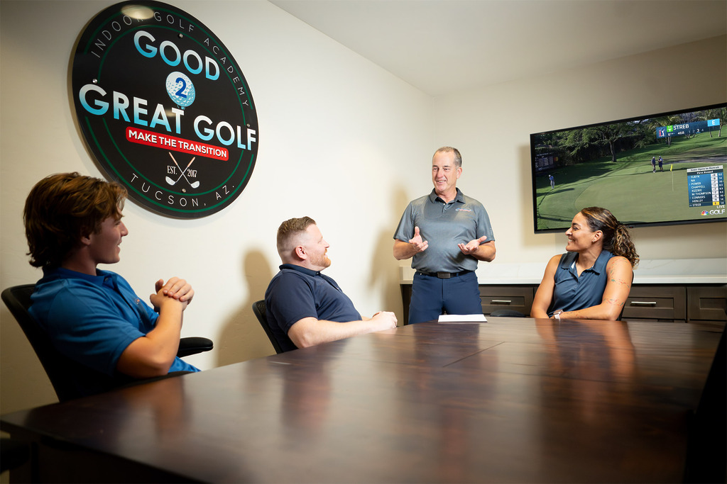 Golf instructor leading meeting at academy office