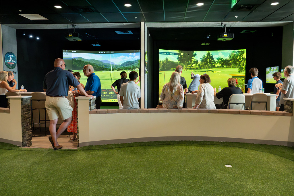 People playing golf in indoor simulator bays