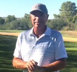 Man in golf attire standing on a course